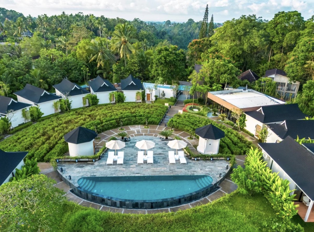 Tanada Resort Ubud — letecký pohled na areál s obloukovým bazénem v zeleni