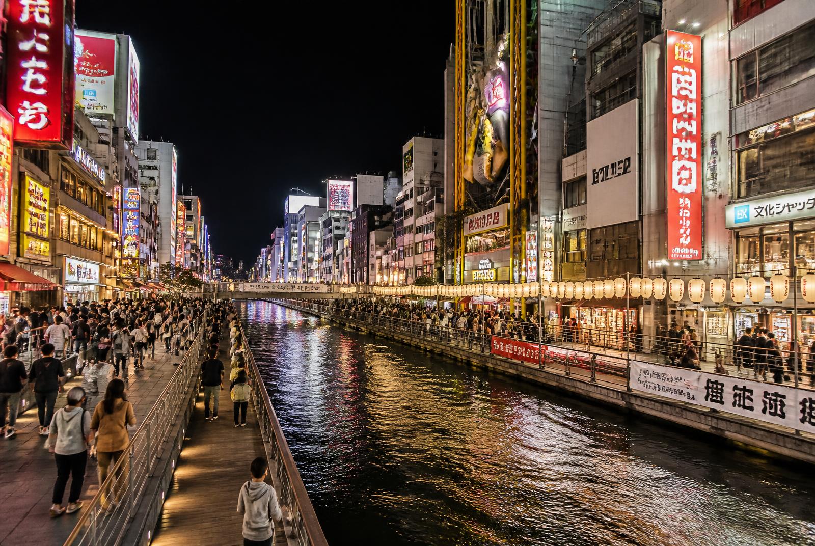 Večerní Dotonbori v Ósace s neonovými reklamami nad kanálem